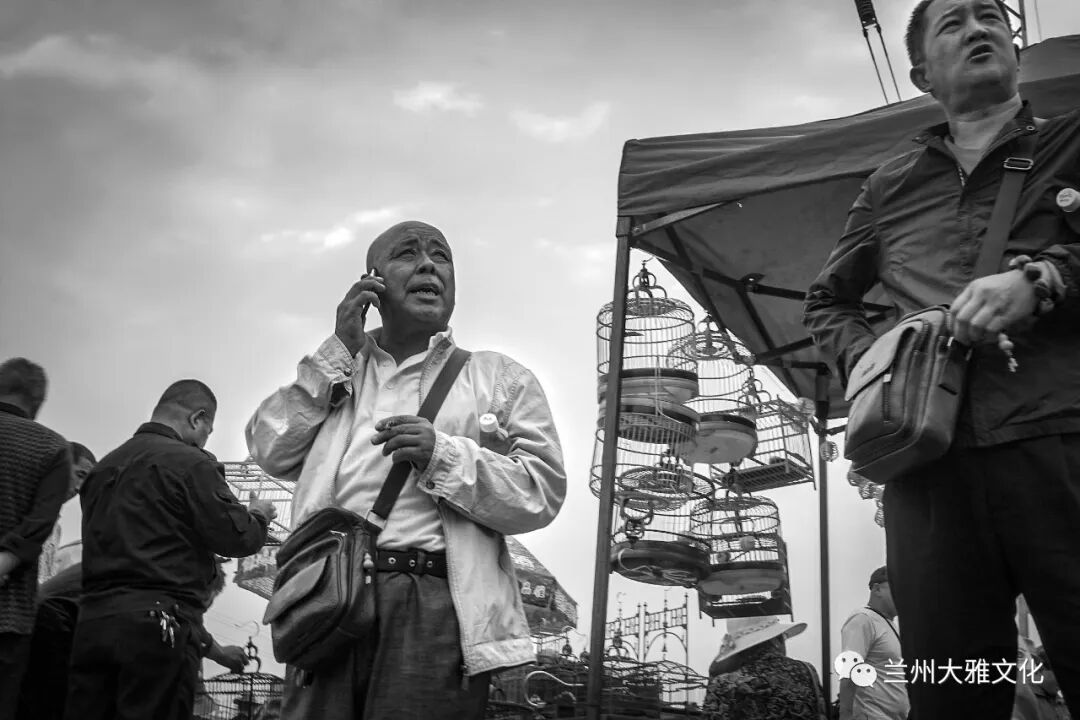 打电话的卖鸟人.2021年4月4日.七里河天畅物流园地摊市场.蒸蒸日上.