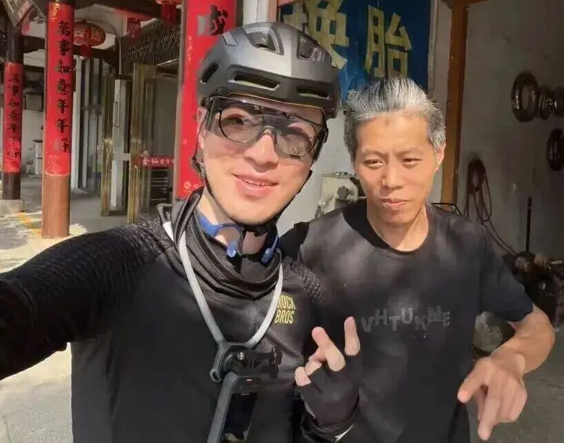 △黄清昊在修车铺与帮助他的师傅合影