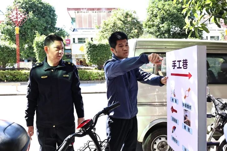 城管工作人员根据居民、摊主建议，决定对指示牌进行改造升级。