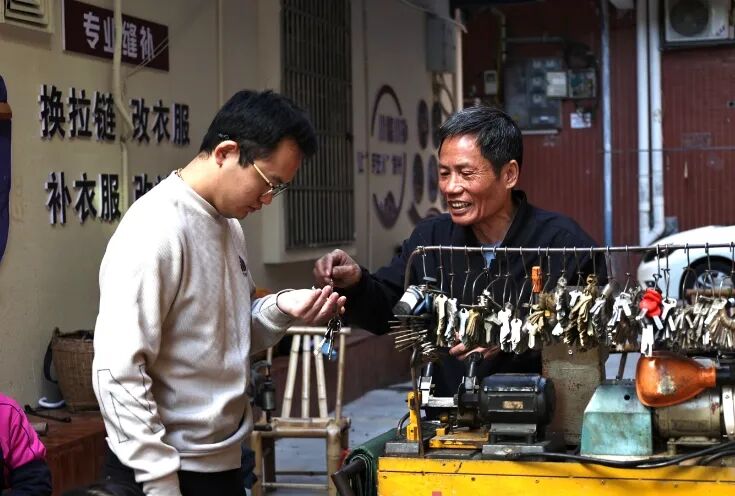 “手工巷”里，居民到小摊配钥匙。