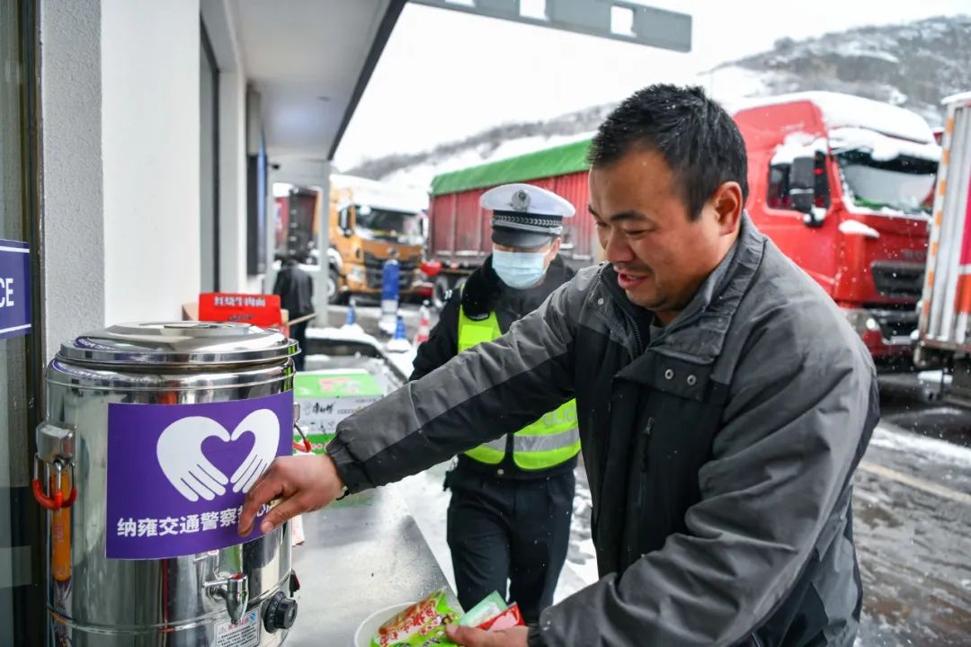 廈蓉高速納雍收費站前,天空飄著大雪,由於高速路封閉,滯留車輛排成了