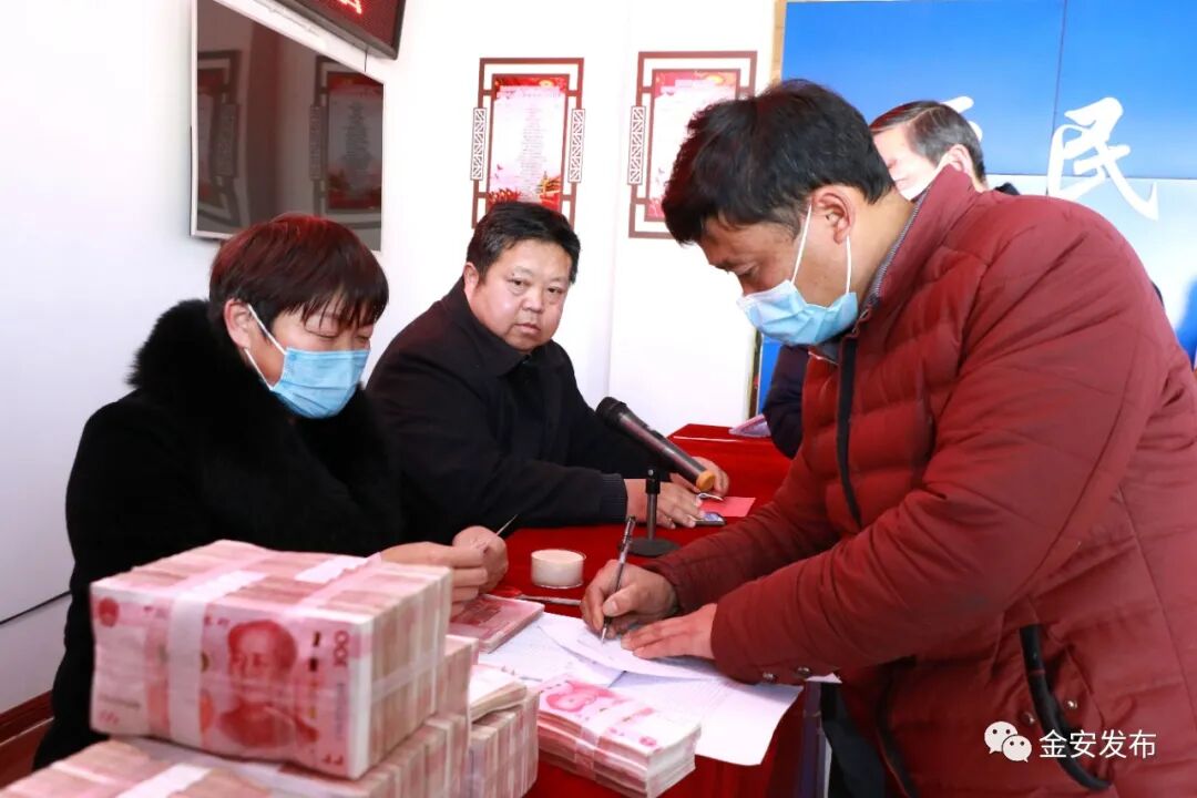 在分红现场,村民们秩序井然地签字,盖手印,领取现金,大家都热情高涨