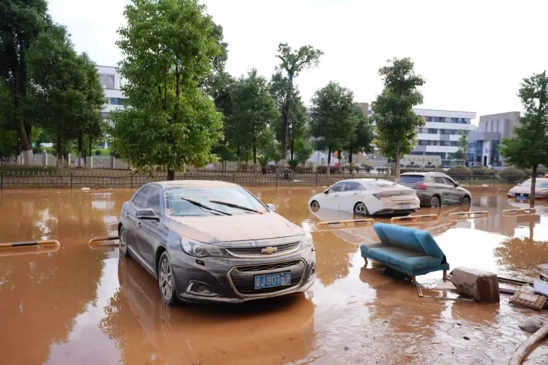 湖南平江洪水渐退 路上停满泥车