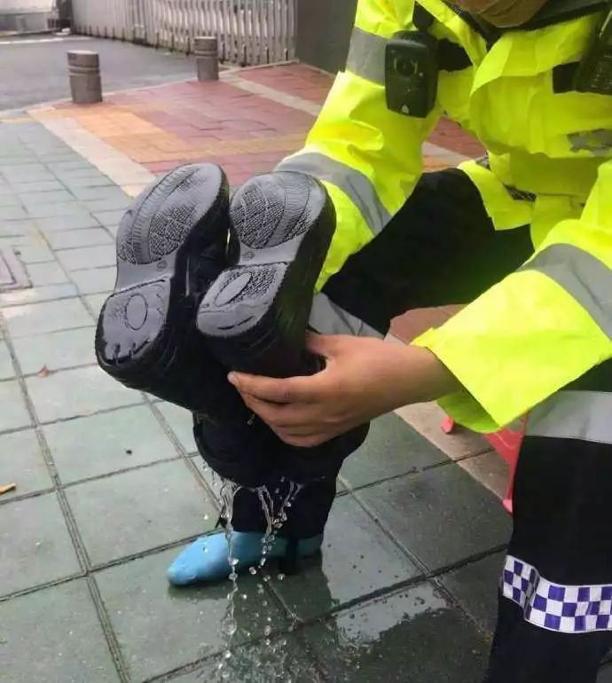 请看这位警察,雨靴里都进了这么多雨水!