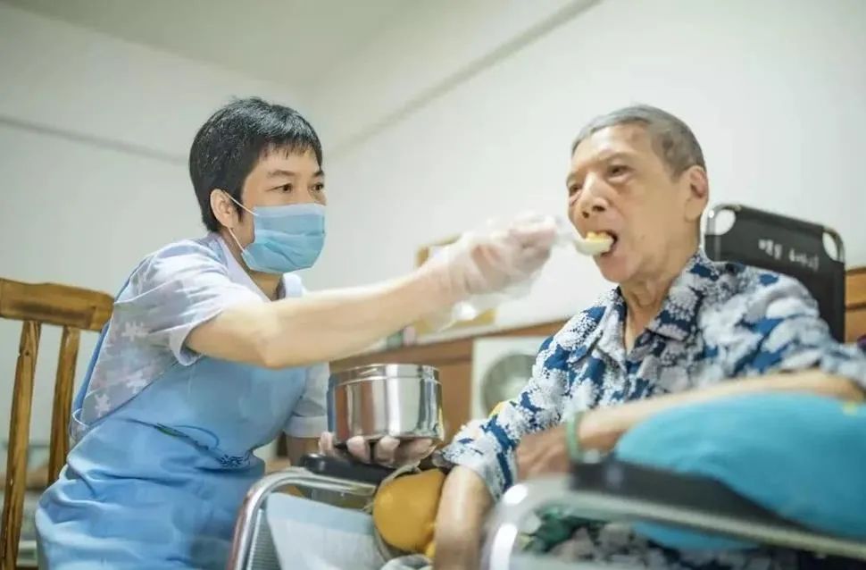护理员在给老人喂食