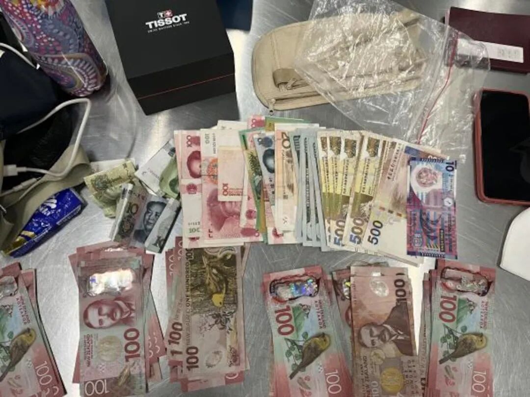 Cash believed to have been collected from victims was seized from the accused trio after they were arrested by Auckland City Financial Crime Unit detectives. Photo / NZ Police