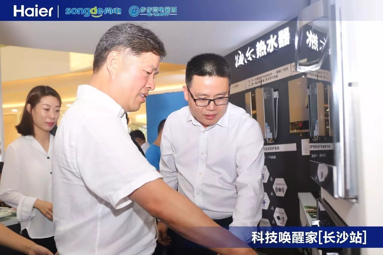 步步高集团董事长王瑱(左)听取海尔湖南分公司总经理左栋(右)介绍产品