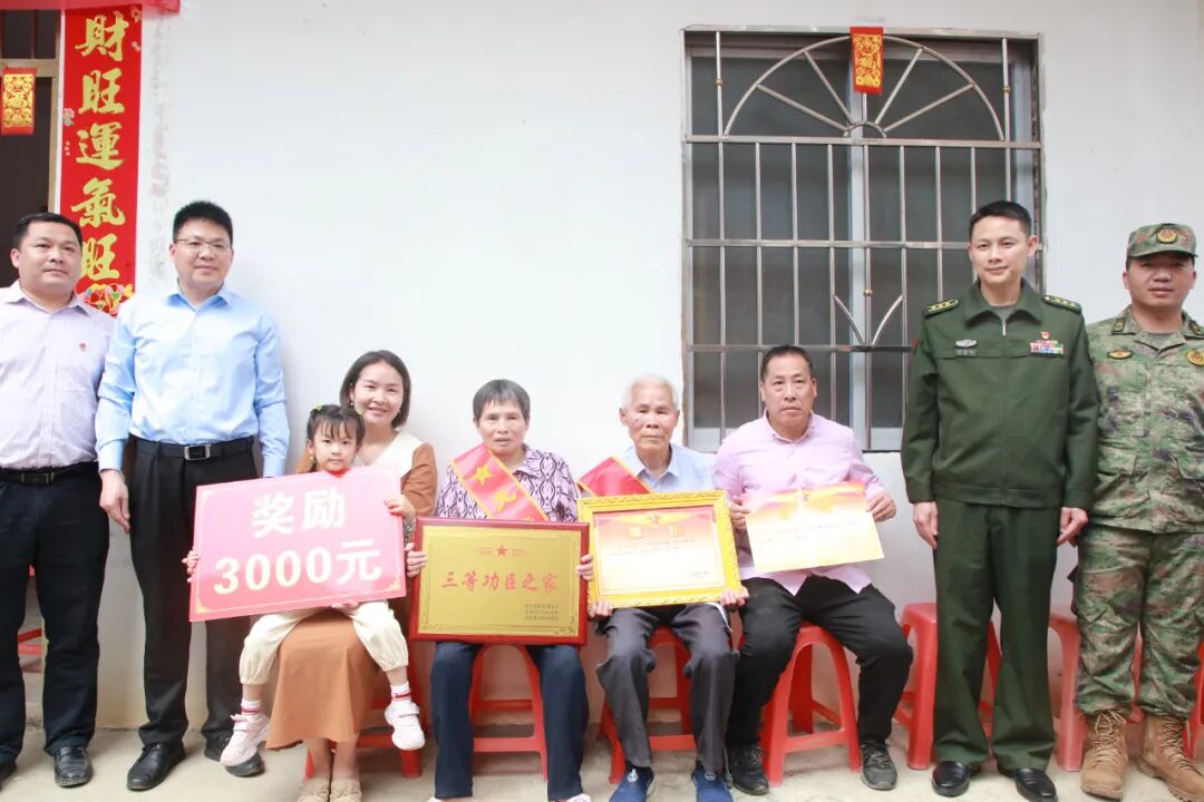 在周怡昌家门前,蒙陆斌,李燕义为其亲属送上了"三等功臣之家"牌匾