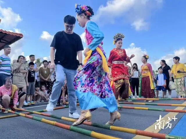 在海宴镇五丰村，东盟国家在粤留学生与归侨后人同跳竹竿舞。