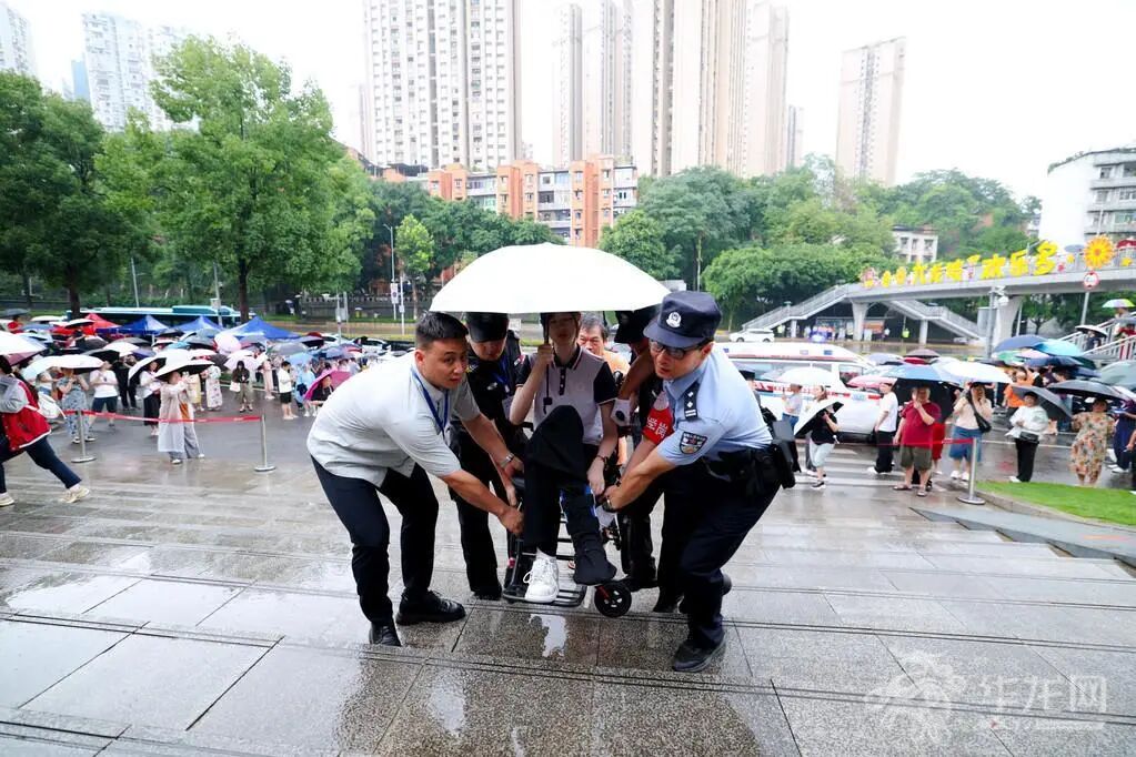 12——九龙坡区育才中学考点，一名坐轮椅的考生在护送下进入考场。