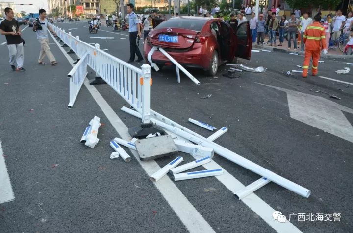 大道路口发生一起交通事故,一辆红色小车猛烈撞击路边的交通隔离栏