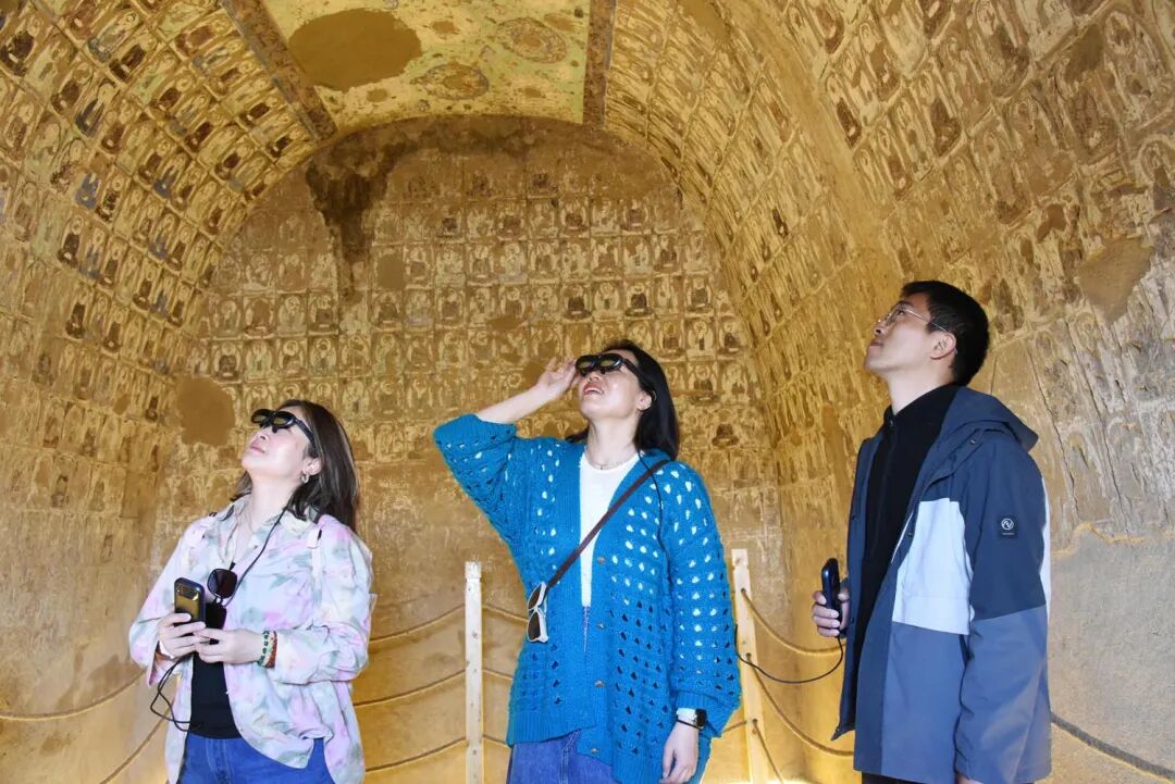 吐鲁番雅尔湖石窟首次开放。图为游客通过AR数字技术观赏石窟内精美的壁画。刘健摄