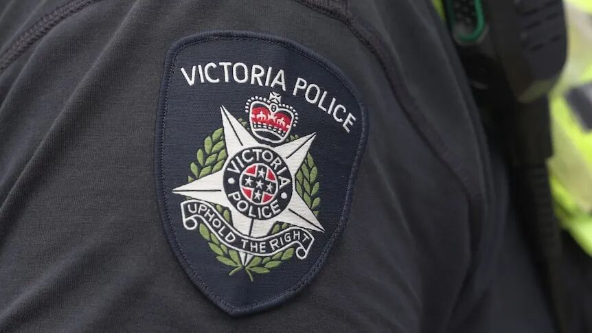 A patch on a police officer's arm reads Victoria Police: uphold the right.