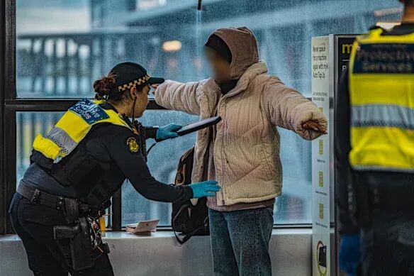A protective services officer conducts a wand search during an operation in 2023.