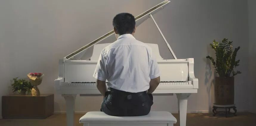 （图）传锡坐在钢琴前