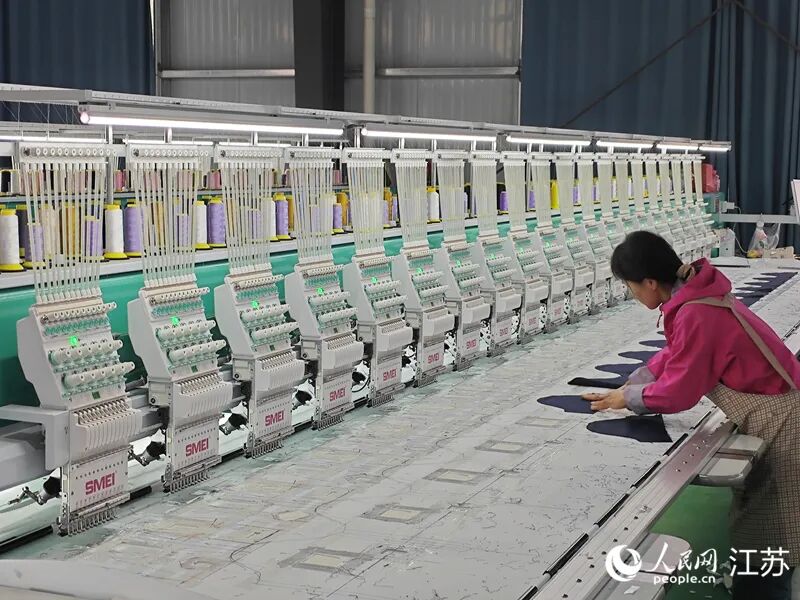 女工陈利操作电脑绣花机。人民网 李欣阳摄