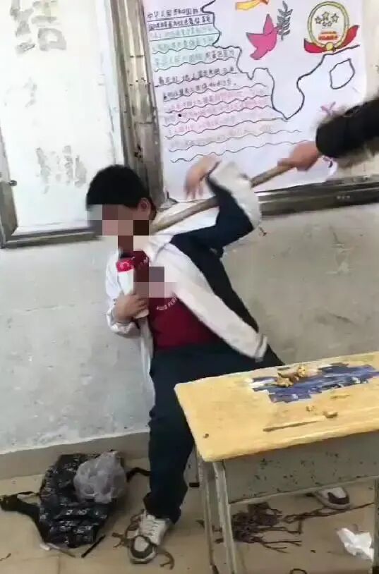 该男生被同学用笤帚顶着胸部