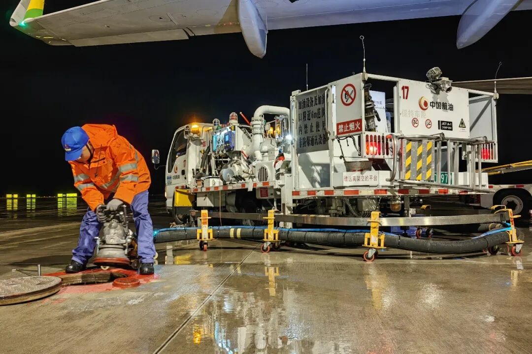 2.中国航油贵州分公司航空加油站飞机加油员雨夜为飞机加油，正在连接地井栓接头.jpg
