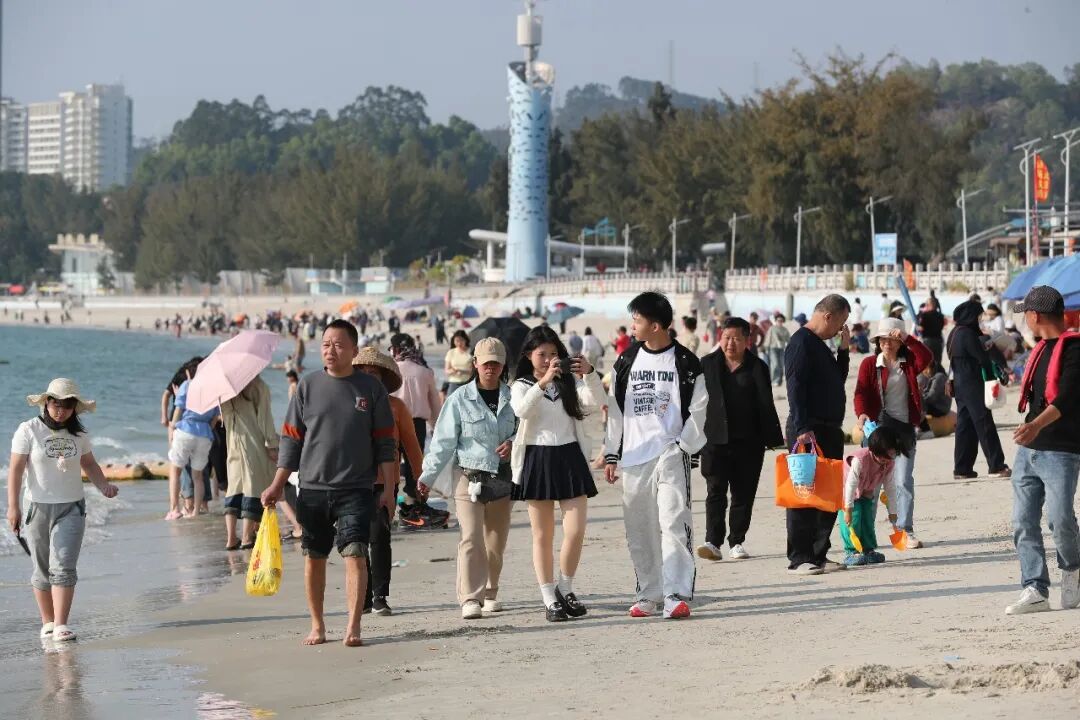 巽寮湾的碧海沙滩上，游人踏浪赏景、乐享滨海年味。张艺明 摄