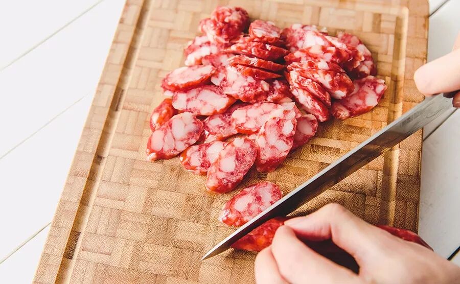▼ 2. 切腊肠腊肉:腊肠斜切成片.