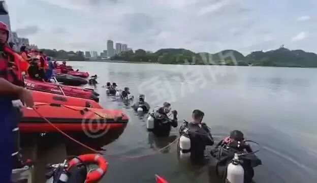 潜水员一字排开在坠湖现场展开地毯式搜救