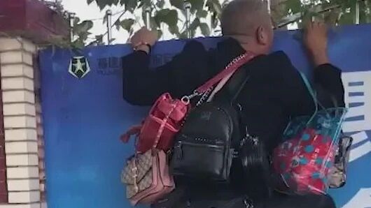 操碎了心！驾校教练背一堆包趴墙看学员考试