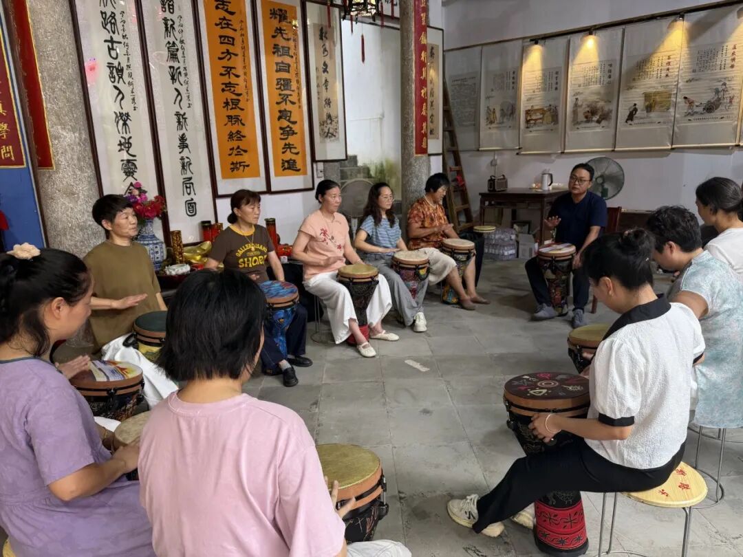 2026年7月5日上午，何斯路村村民们在祠堂里学习演奏非洲鼓。（南方周末记者韩谦|摄）