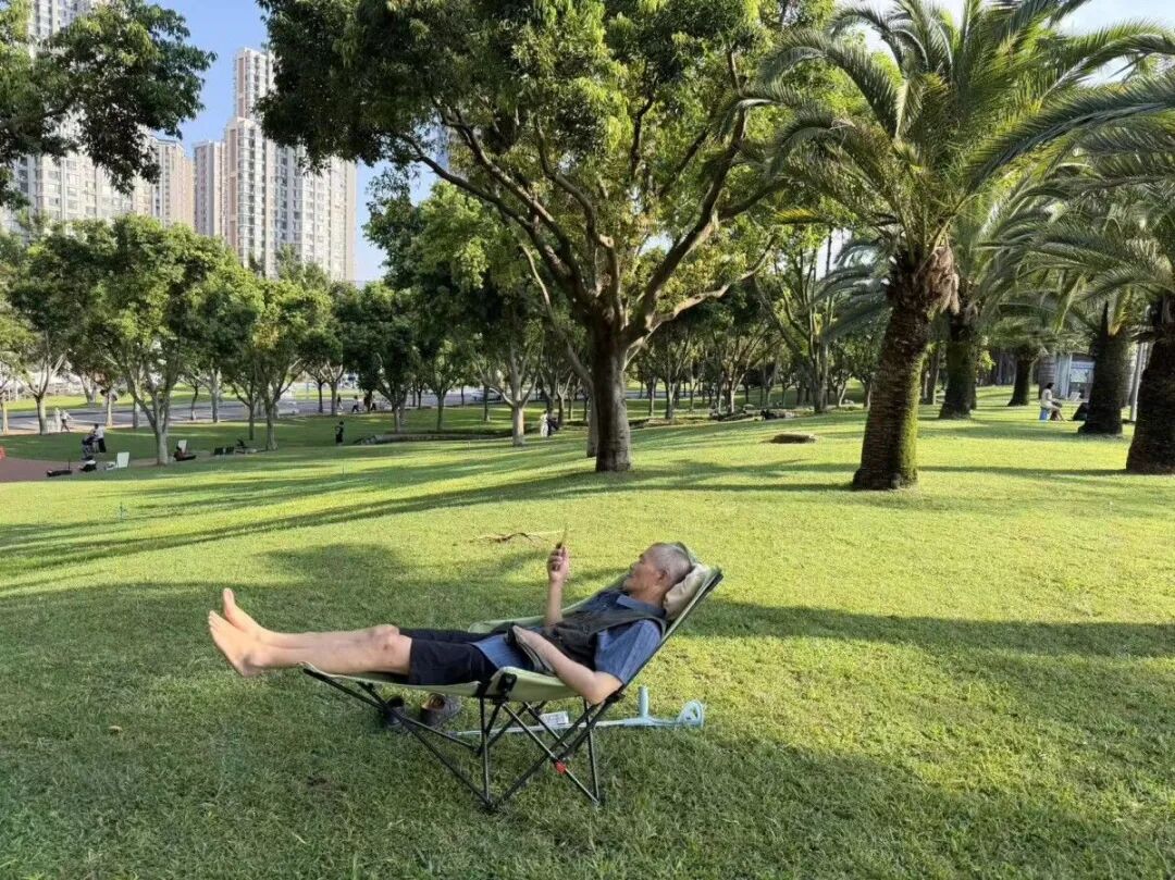 一位脑梗的老人在弥勒的公园绿地上吹风晒太阳。