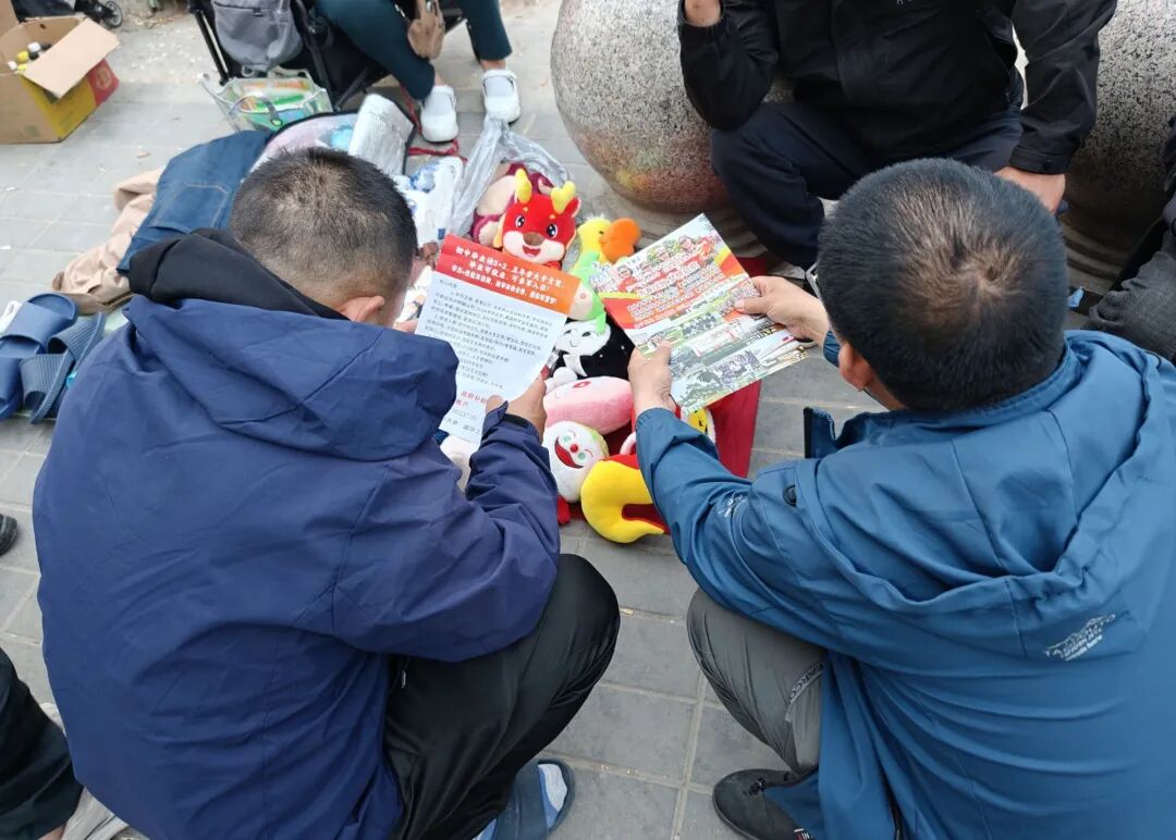 两位工人正在看自考专科文凭广告。(南方周末记者 陈鹏/摄)