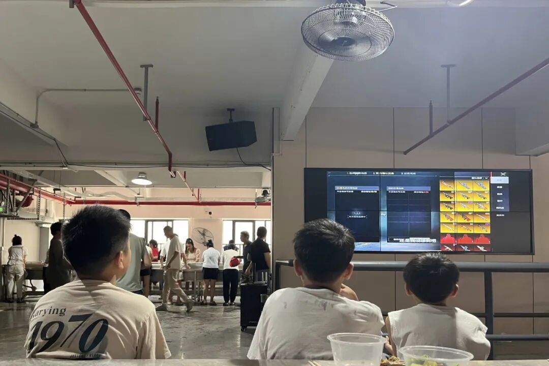 2026年7月25日，广州新塘镇，三个男孩在看电视上播放的游戏视频集锦。（苏有鹏/摄）