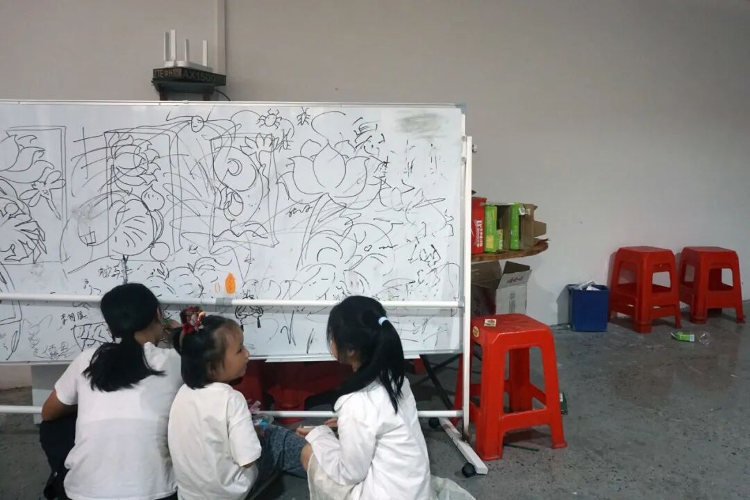 2026年7月25日，广州新塘镇，三个女孩涂鸦画画，白板也是托管班的娱乐设施。（苏有鹏/摄）