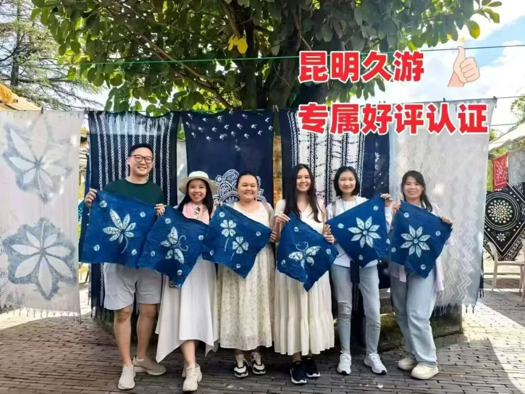 喜洲扎染体验，客人举着自己的扎染作品合影