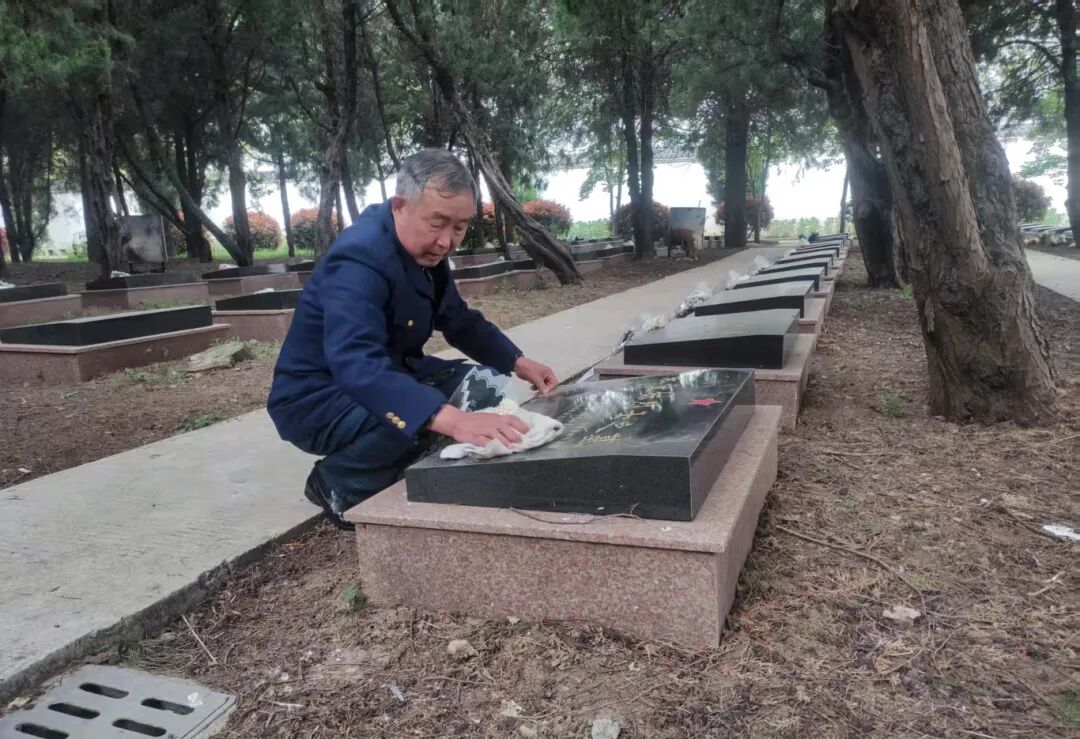 图为盛志擦拭陵园烈士墓碑.jpg