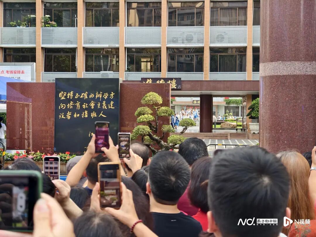 华附考点门口，许多家长争相拍摄考生过“状元桥”景象。