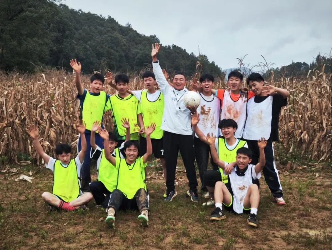 贵州普安县罗汉中学校长欧阳谦带着学生在玉米地里踢球。（受访者供图）
