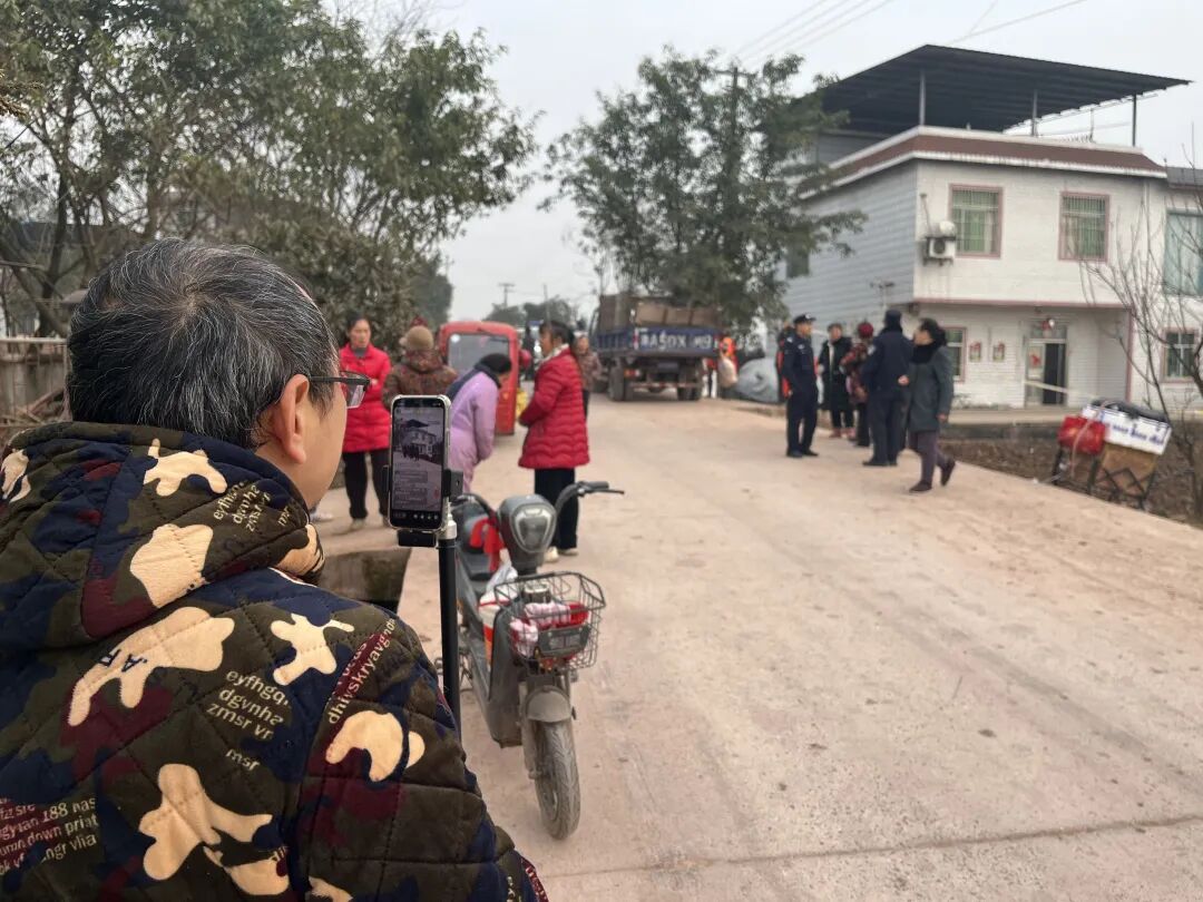 2026年1月15日，重庆市合川区庆福村。呆呆家院子拉起了警戒线，村里老人聚在一块儿回忆刨猪宴盛况。不少主播在边上直播，直播间出现最多的话是“想看看呆呆”。(南方周末记者杜寒三/图)