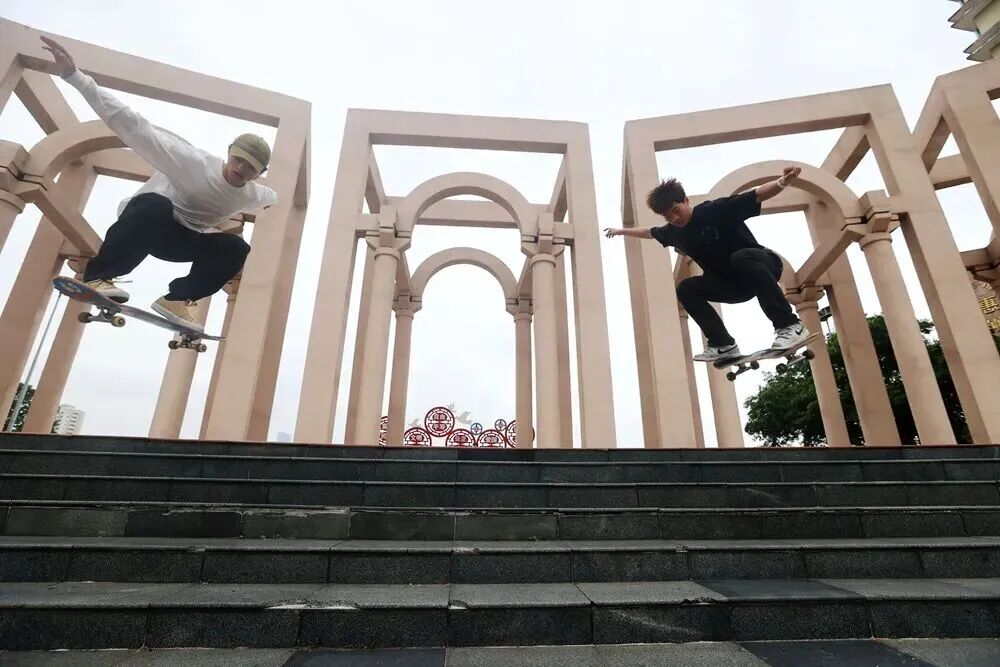 惠州市区下埔滨江公园，青少年滑板爱好者的双人组合飞跃阶梯。杨建业 摄