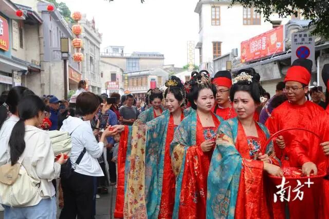 “五一”假期，揭阳古城思贤路上，身着传统服饰的市民参加揭阳市首届结婚周年纪念活动，吸引游客拍照。南方+记者 林捷勇 摄