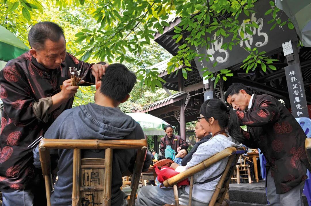 在鹤鸣茶社喝茶的客人,可以同时享受采耳的服务(陈锦 摄)"成都茶馆