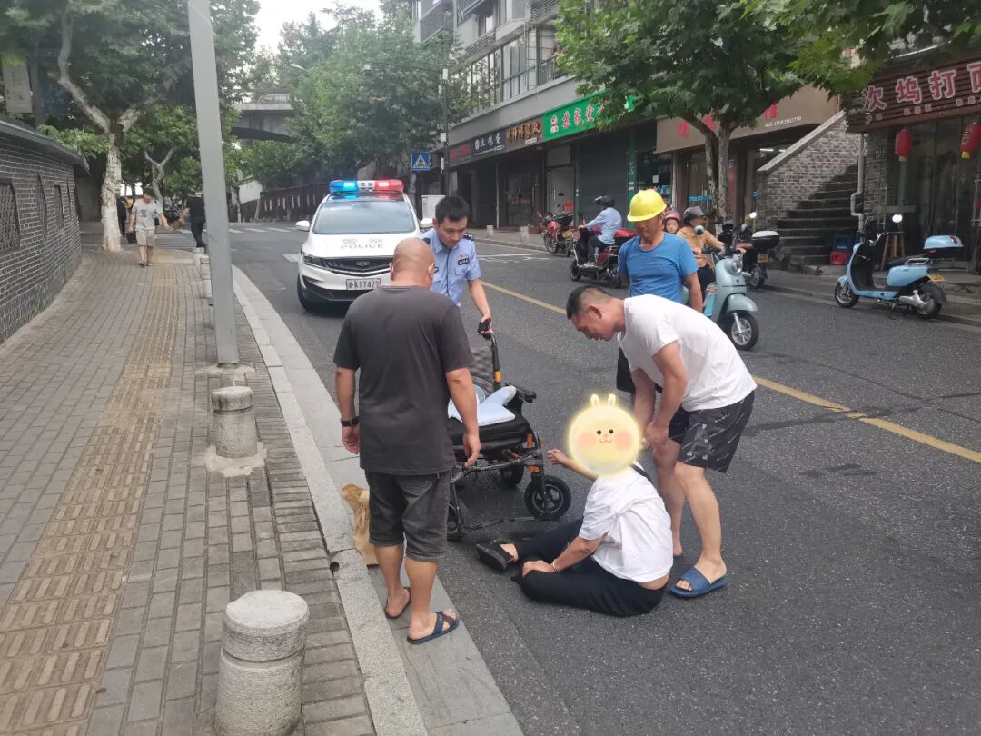 暖心老人轮椅侧翻摔倒在路边警民合力帮助