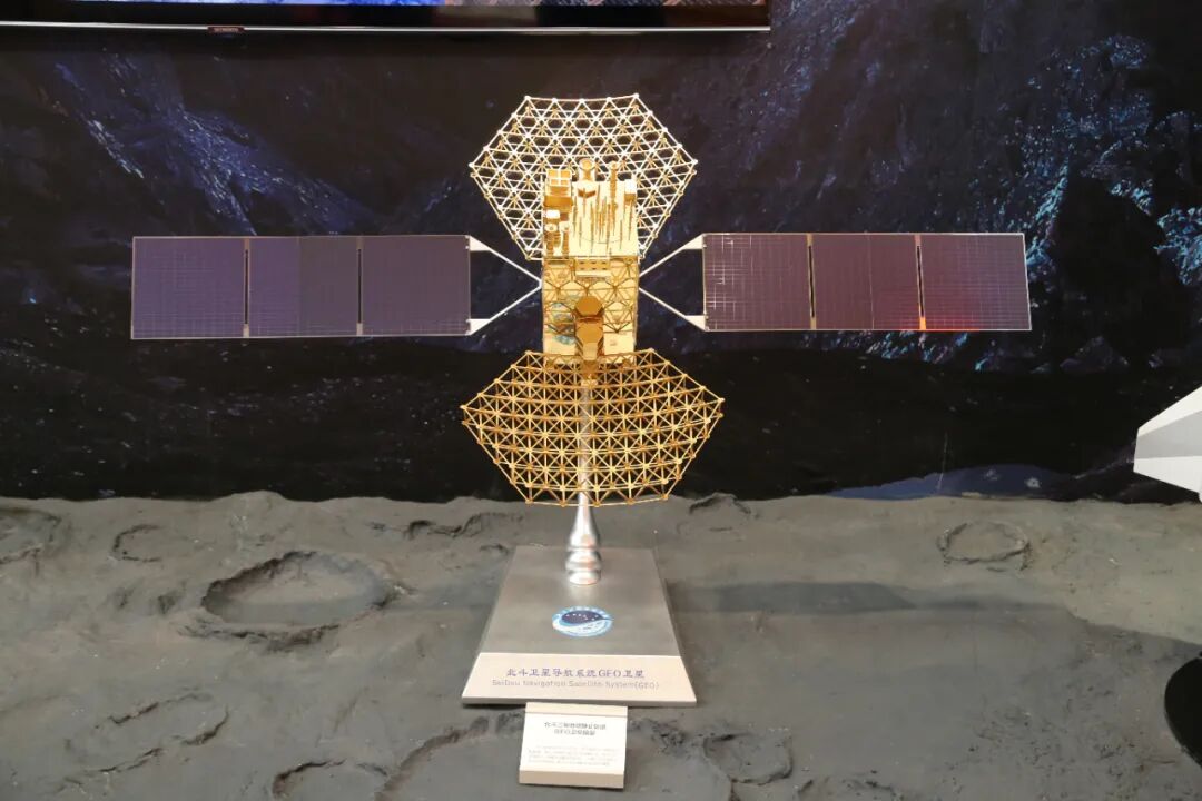 图文展板和卫星模型直观展示了北斗人充分弘扬和传承"自主创新,开放