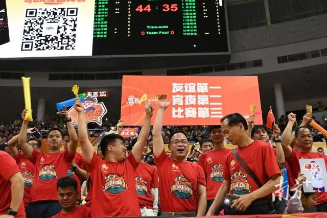 河源球迷高举“友谊第一、宵夜第二、比赛第三”标语。