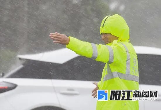 海陵大堤路口，交警冒着风雨在指挥交通。