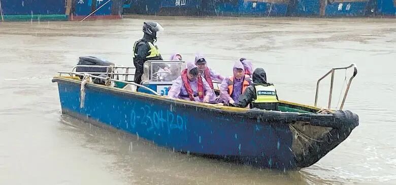 台山市公安局民警在风雨中配合汶村镇开展转移群众工作。