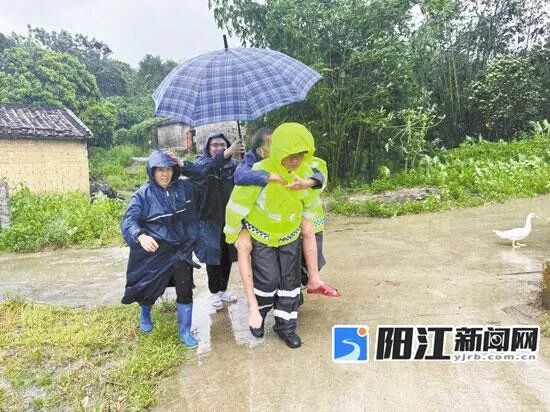 阳西县公安局塘口派出所民警冒雨转移老人。