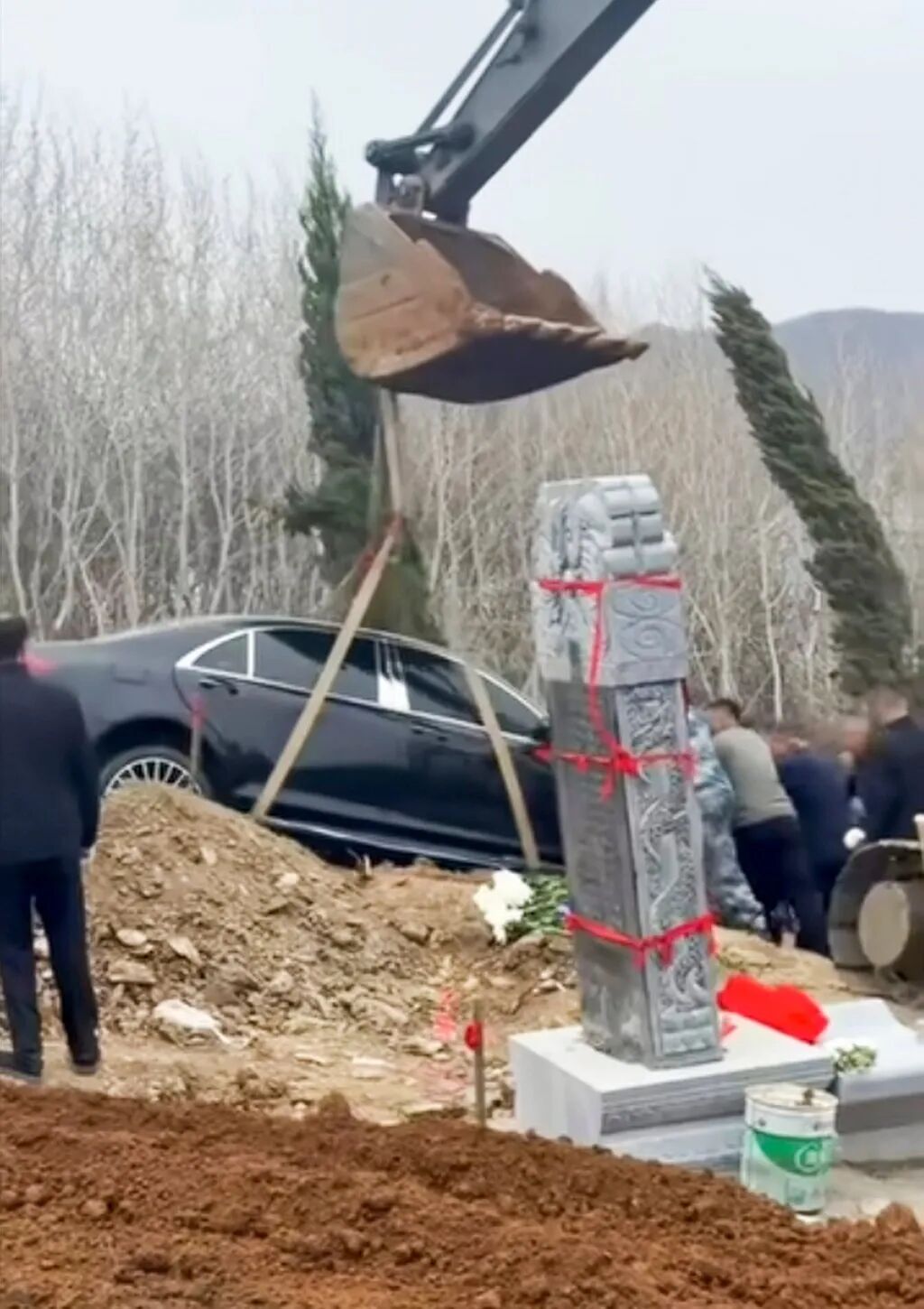 The arm of a mechanical digger lifts the car before it was placed in the “grave”. Photo: bilibili.com
