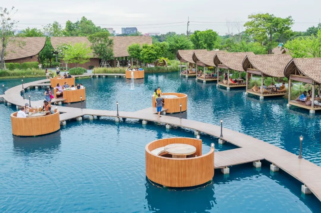 一条优美的弧形木质小桥连接到对岸,连接每个独立的"水上用餐空间".