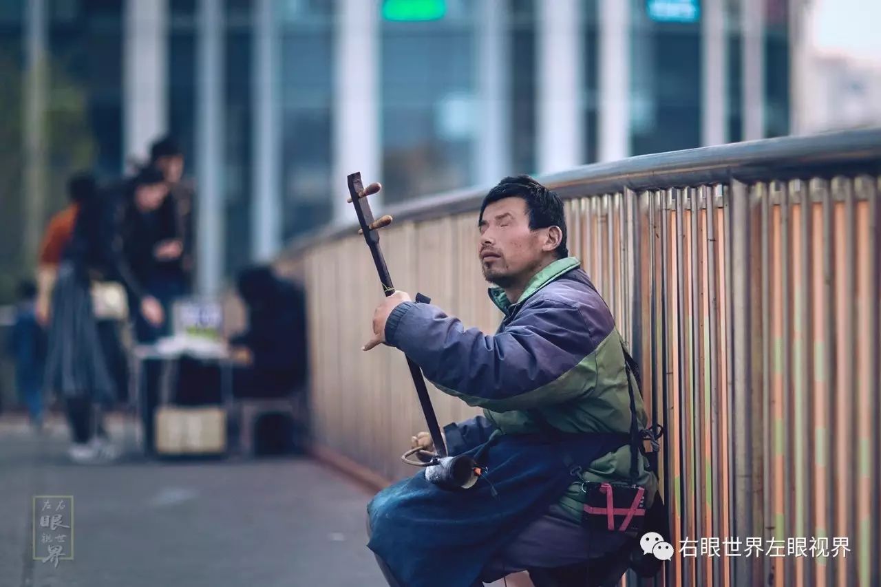 2017年3月20日,三里屯 北京,一位孤独的盲人,靠拉二胡在天桥上乞讨.