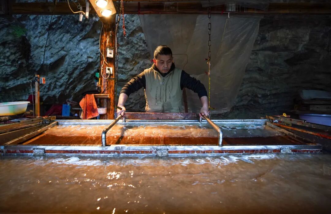     丹寨县南皋乡石桥村古法造纸作坊的工匠在烘焙皮纸