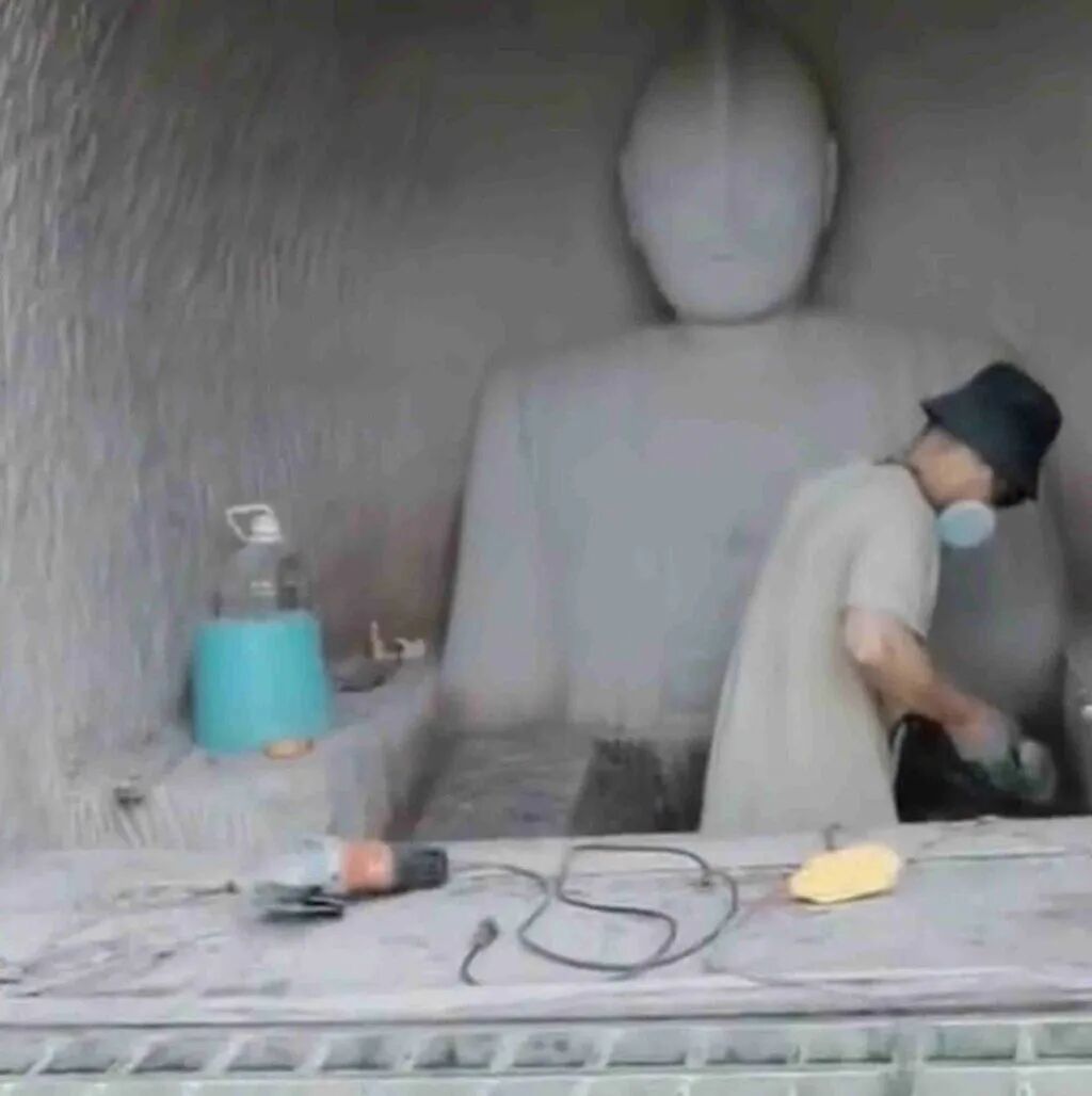 Zhou pictured working as his creation begins to take shape on the cliffside. Photo: Weibo